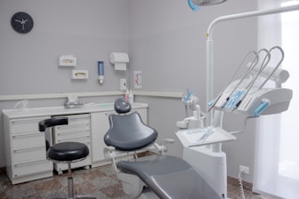 A dental room with a chair and a desk
