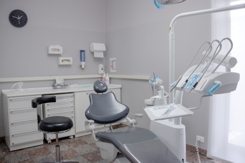 A dental room with a chair and a desk