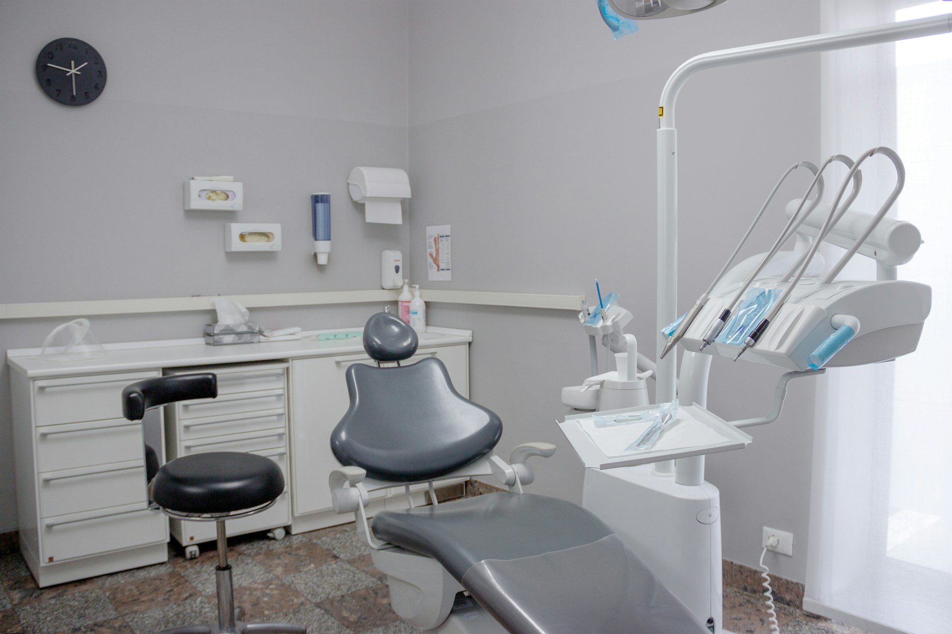 A dental room with a chair and a desk