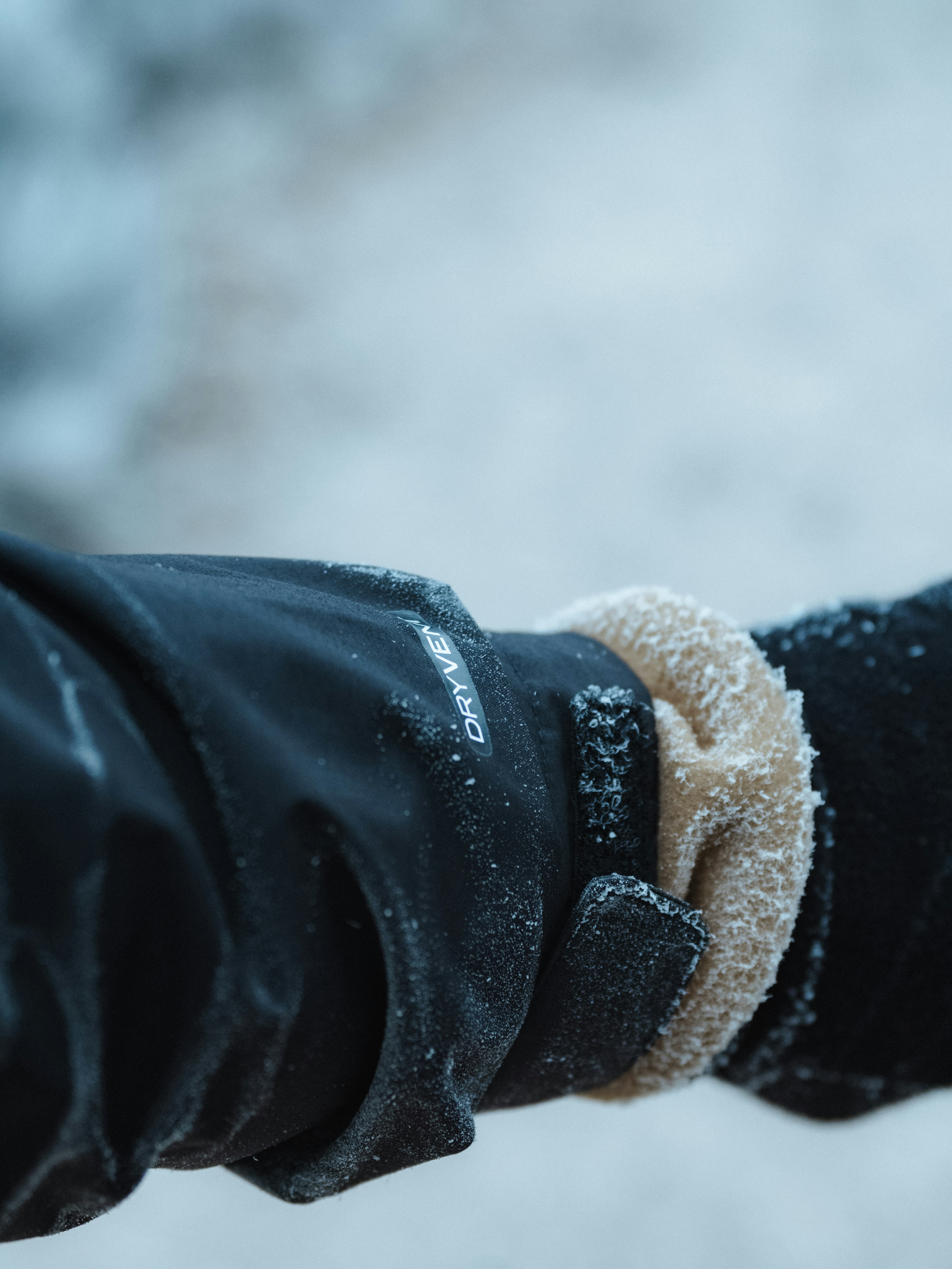 A person wearing black gloves and a white wristband