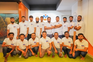 A group of men in white shirts posing for a picture