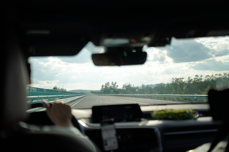 View from the back seat as a driver heads down an open highway after picking up a rental in New Hampshire