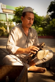 A man sitting on the ground with a brush in his hand