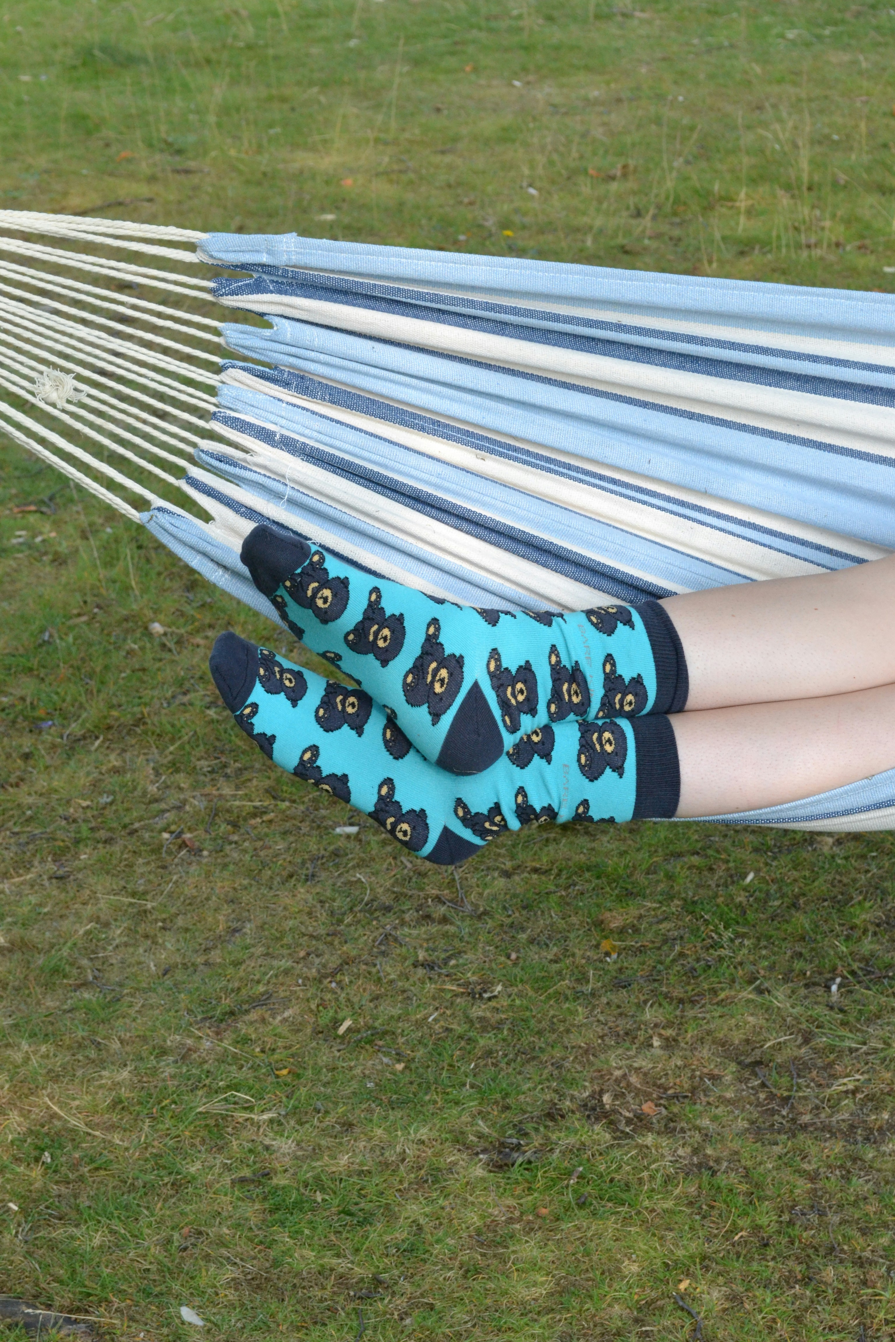 A woman laying in a hammock with her feet propped up