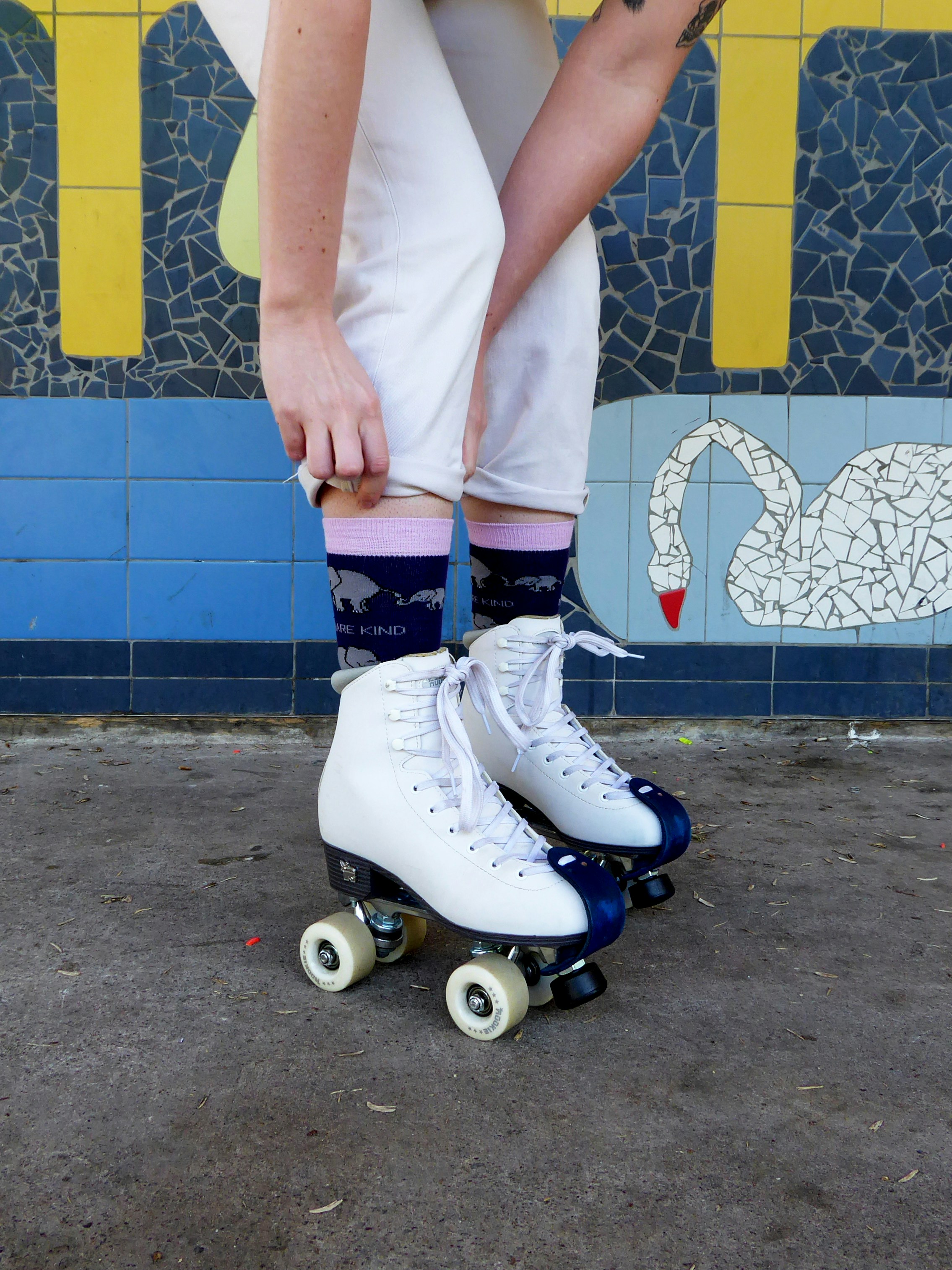A man riding a skateboard down a street next to a wall
