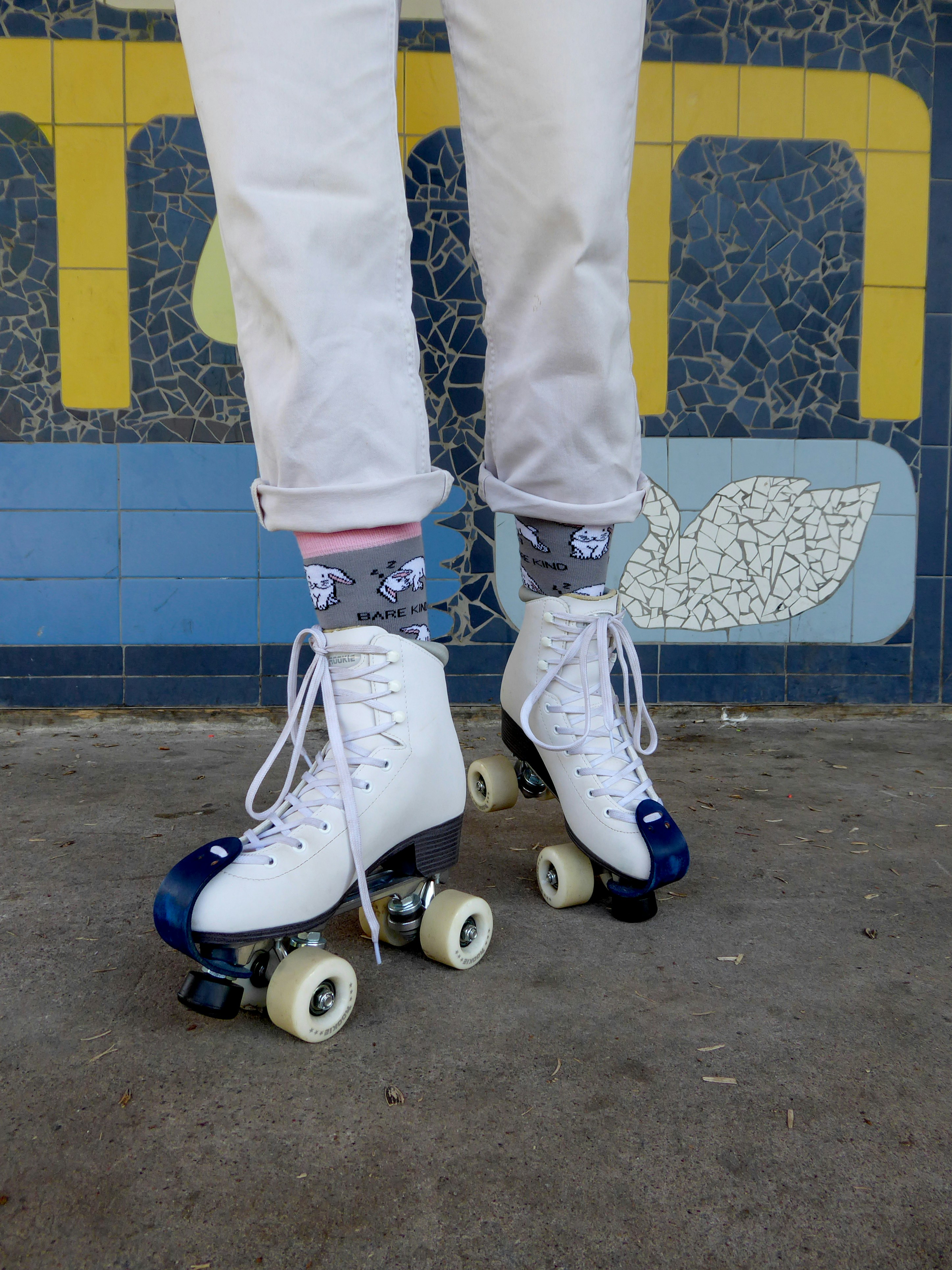 A person standing on roller skates in front of a tiled wall