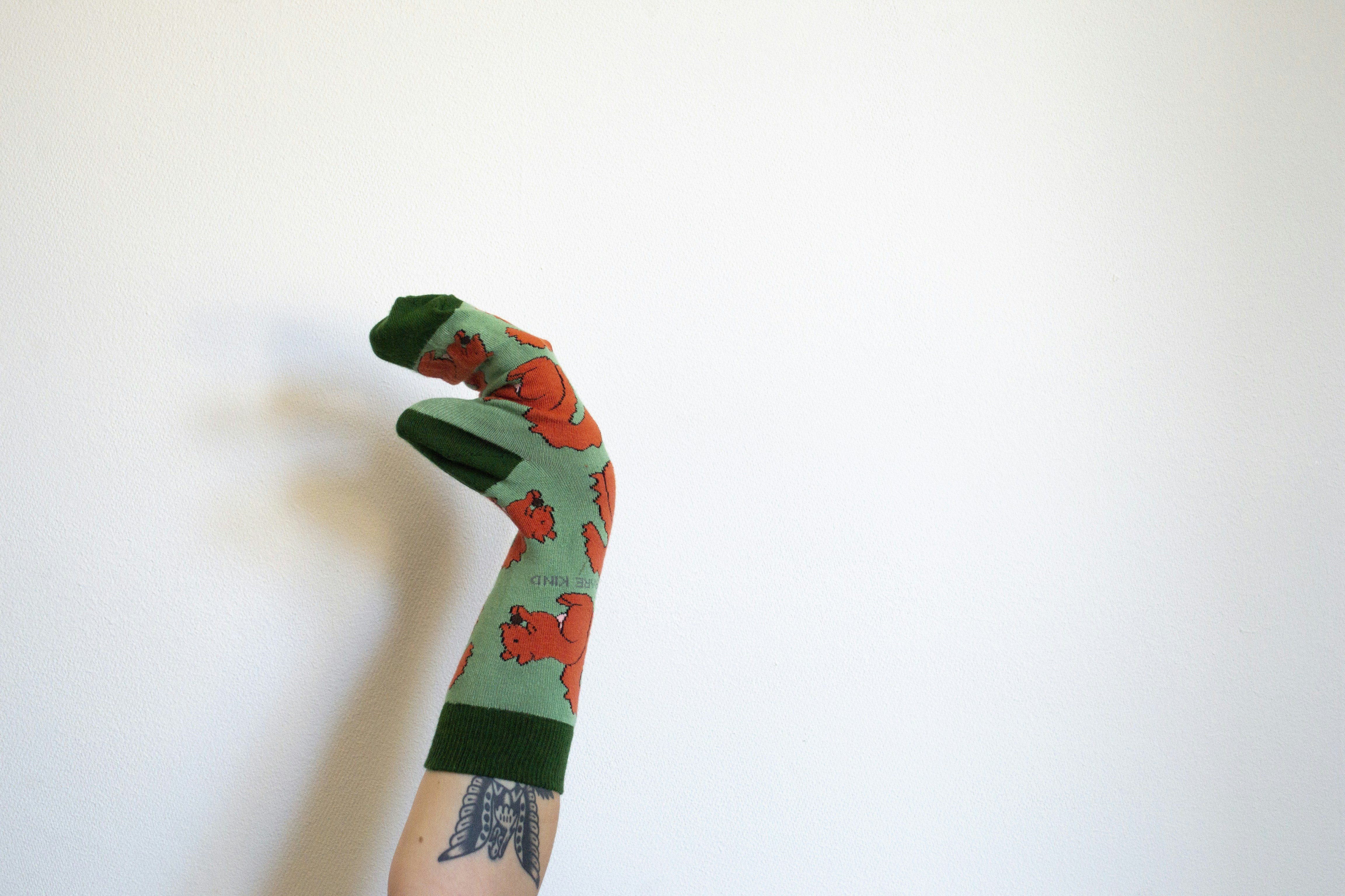 A hand with a green and red armband holding a red and green object