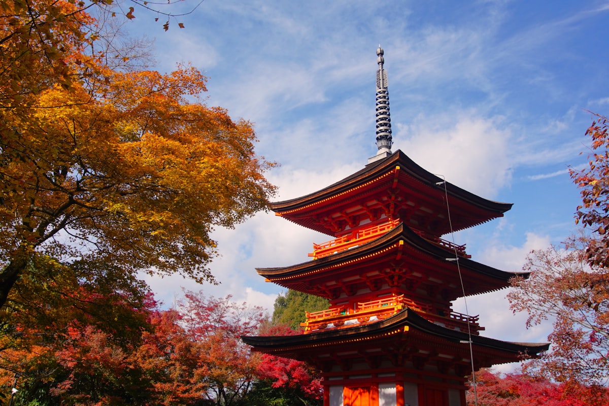 Kyoto October — tall pagoda surrounded by red and orange early autumn foliage