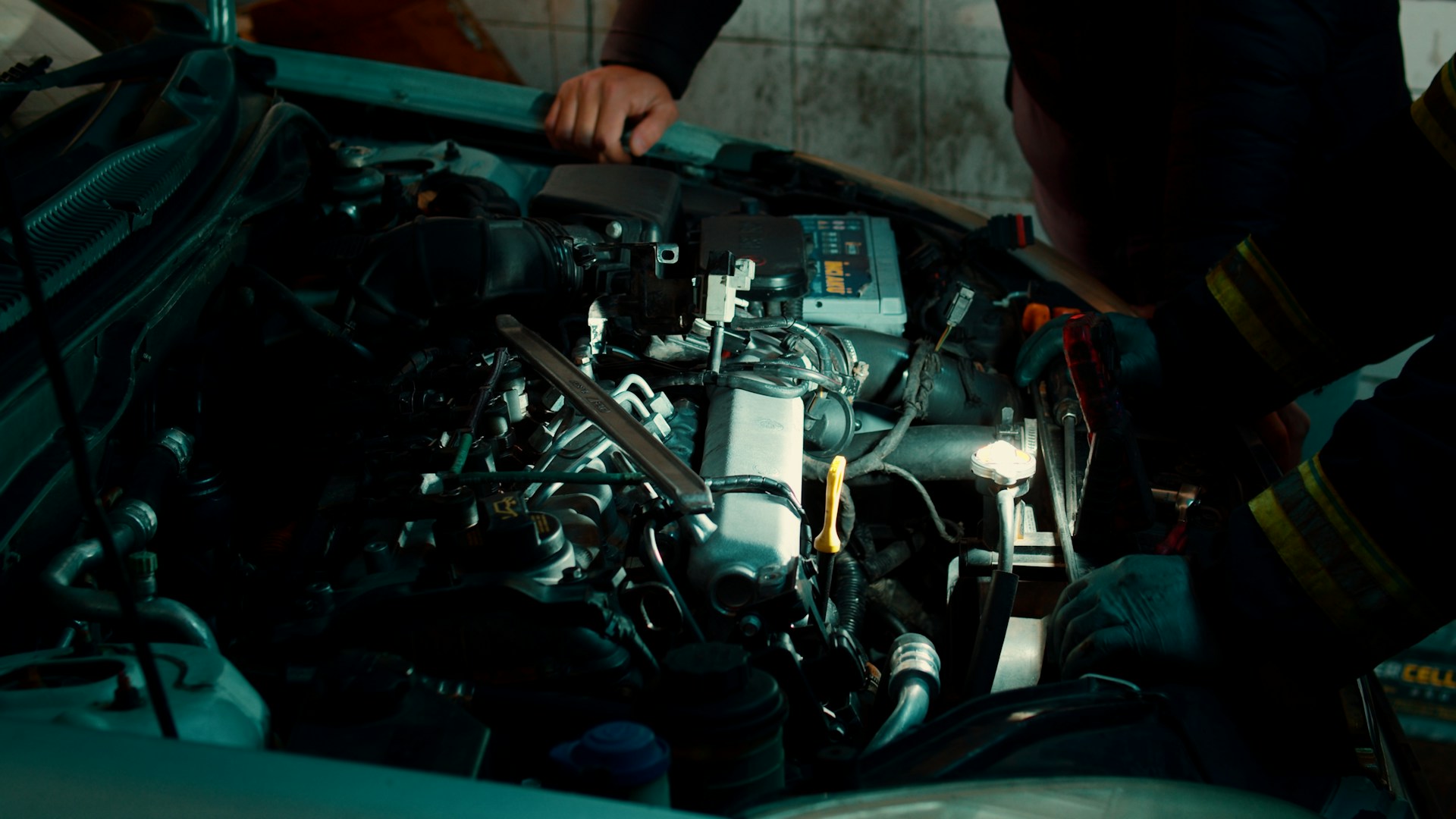 A man working on a car engine in a garage