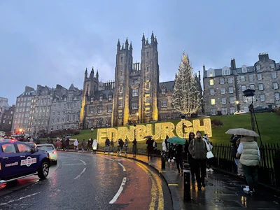 A group of people walking down a street next to a tall building