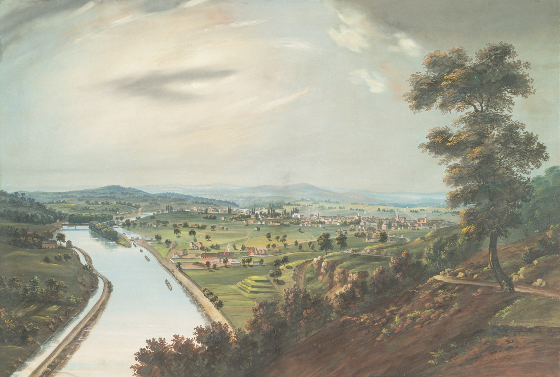 A scenic landscape with a canal and distant town
