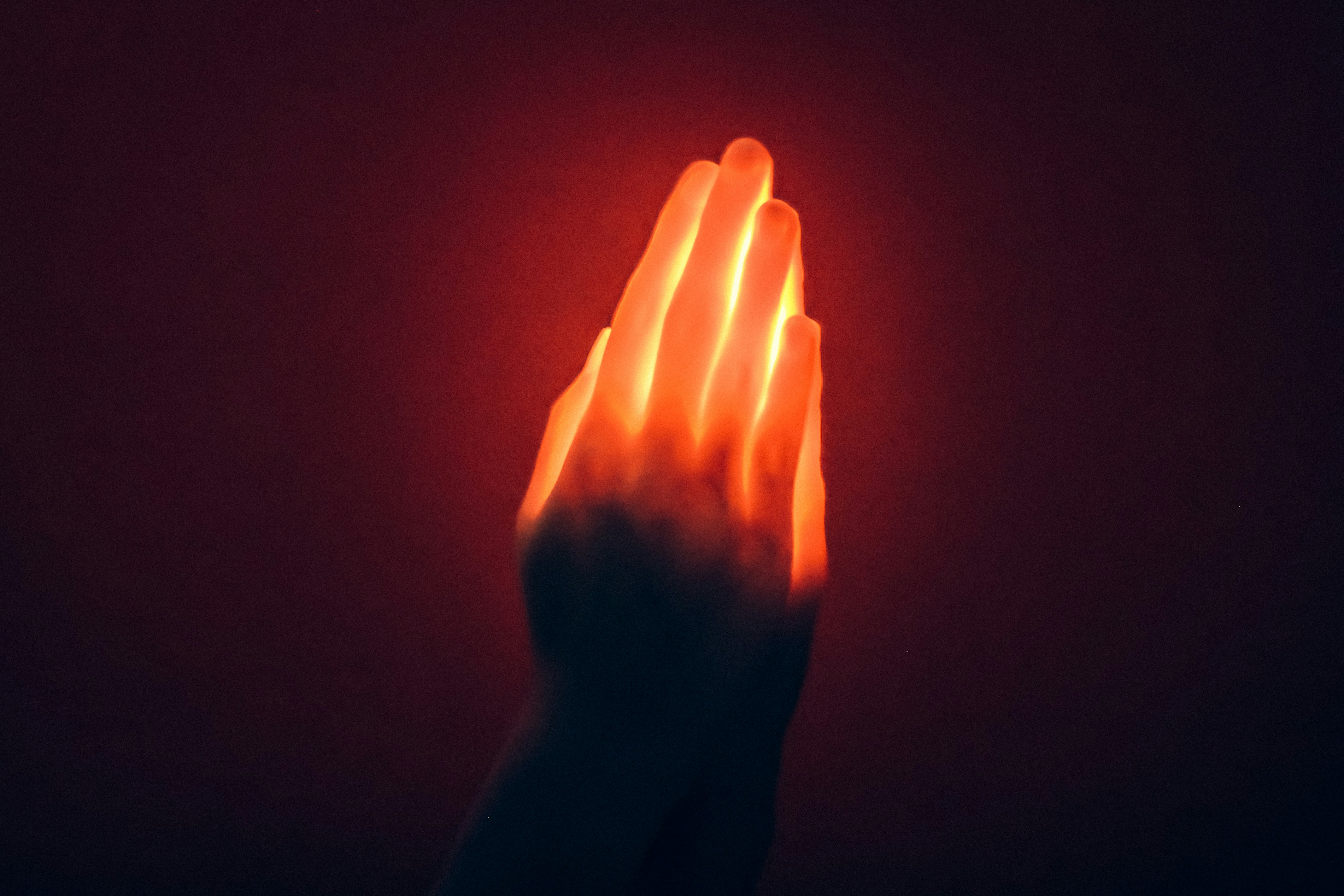 A hand holding a glowing object in the dark