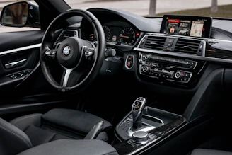 The interior of a car with a steering wheel and dashboard