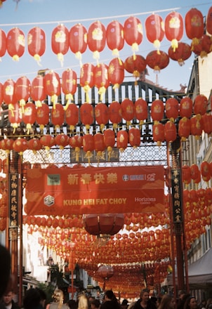 A group of people walking under red lanterns