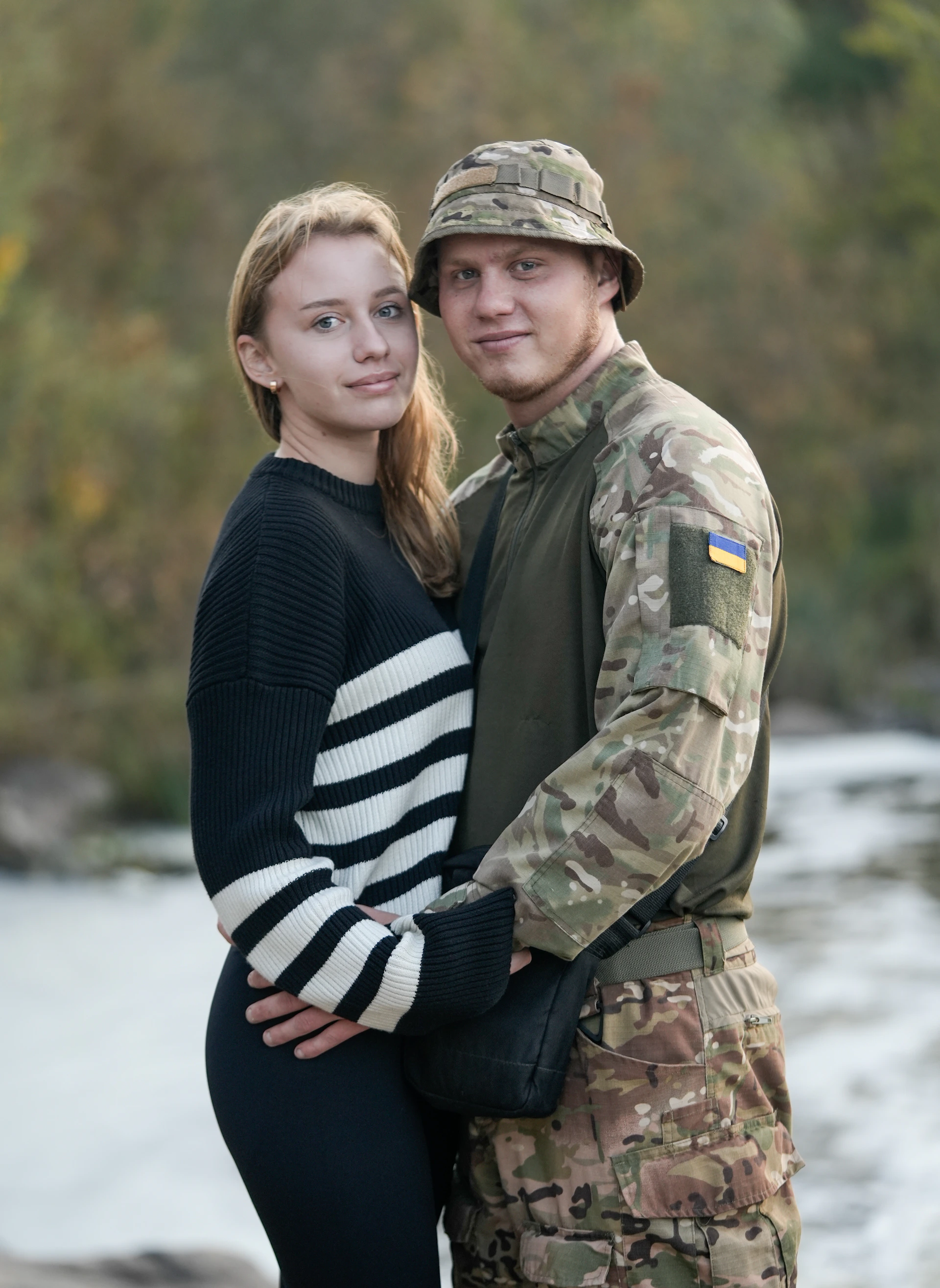 A man and a woman in military clothes standing next to each other