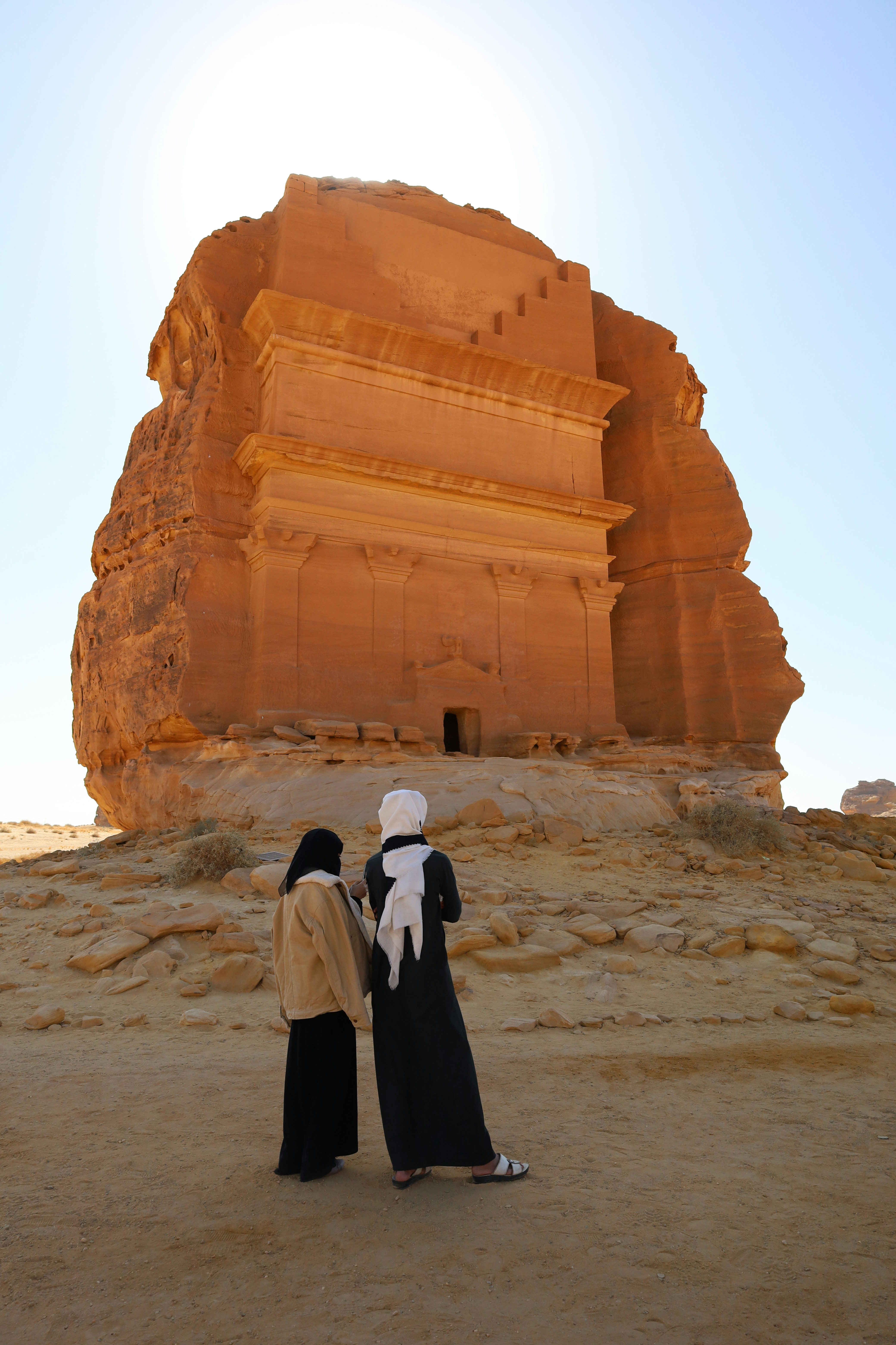 Two women standing in front of a large structure