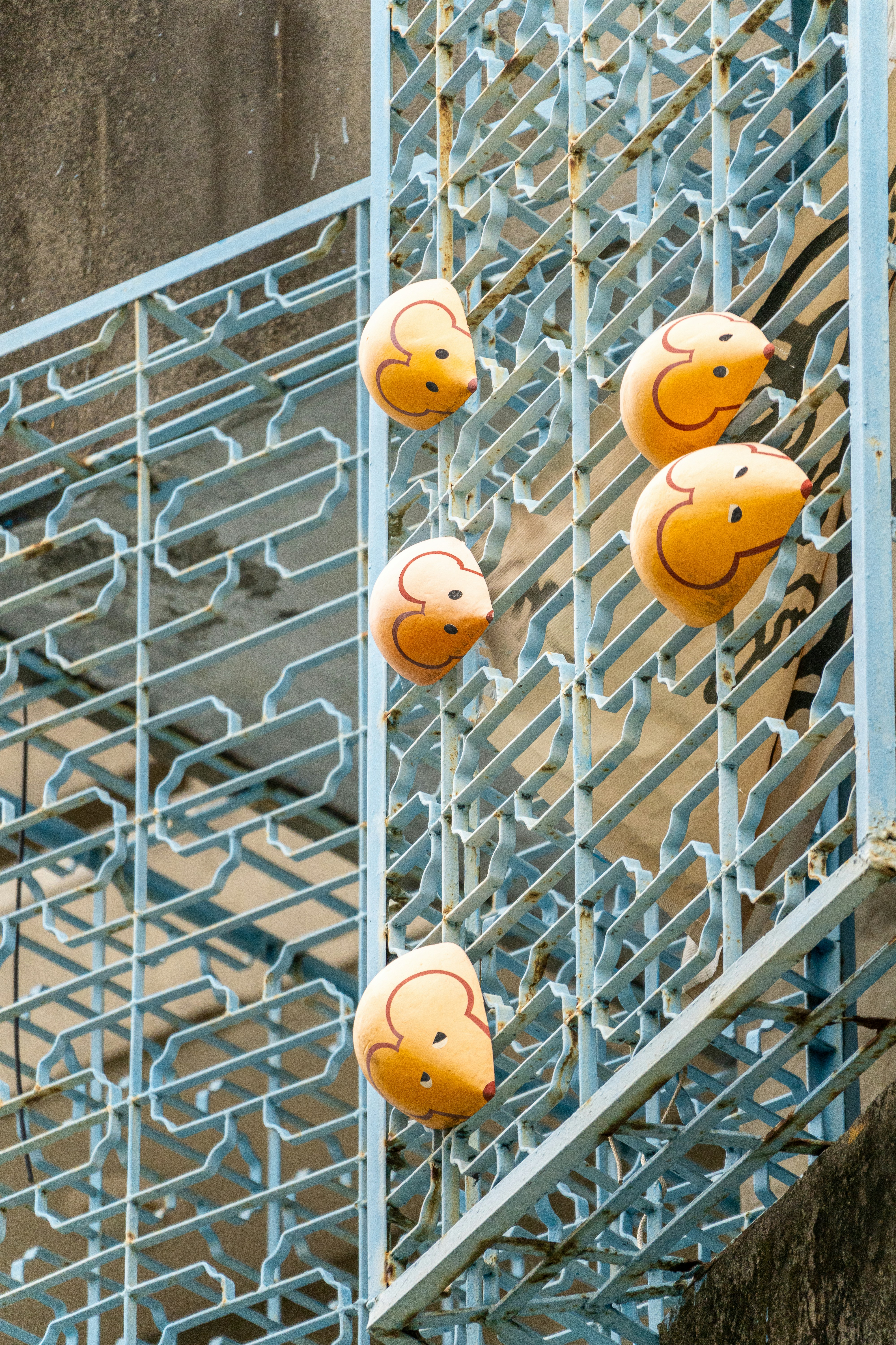 A group of smiley face balloons hanging from a balcony