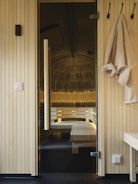 A bathroom with a bench and towels hanging on the wall