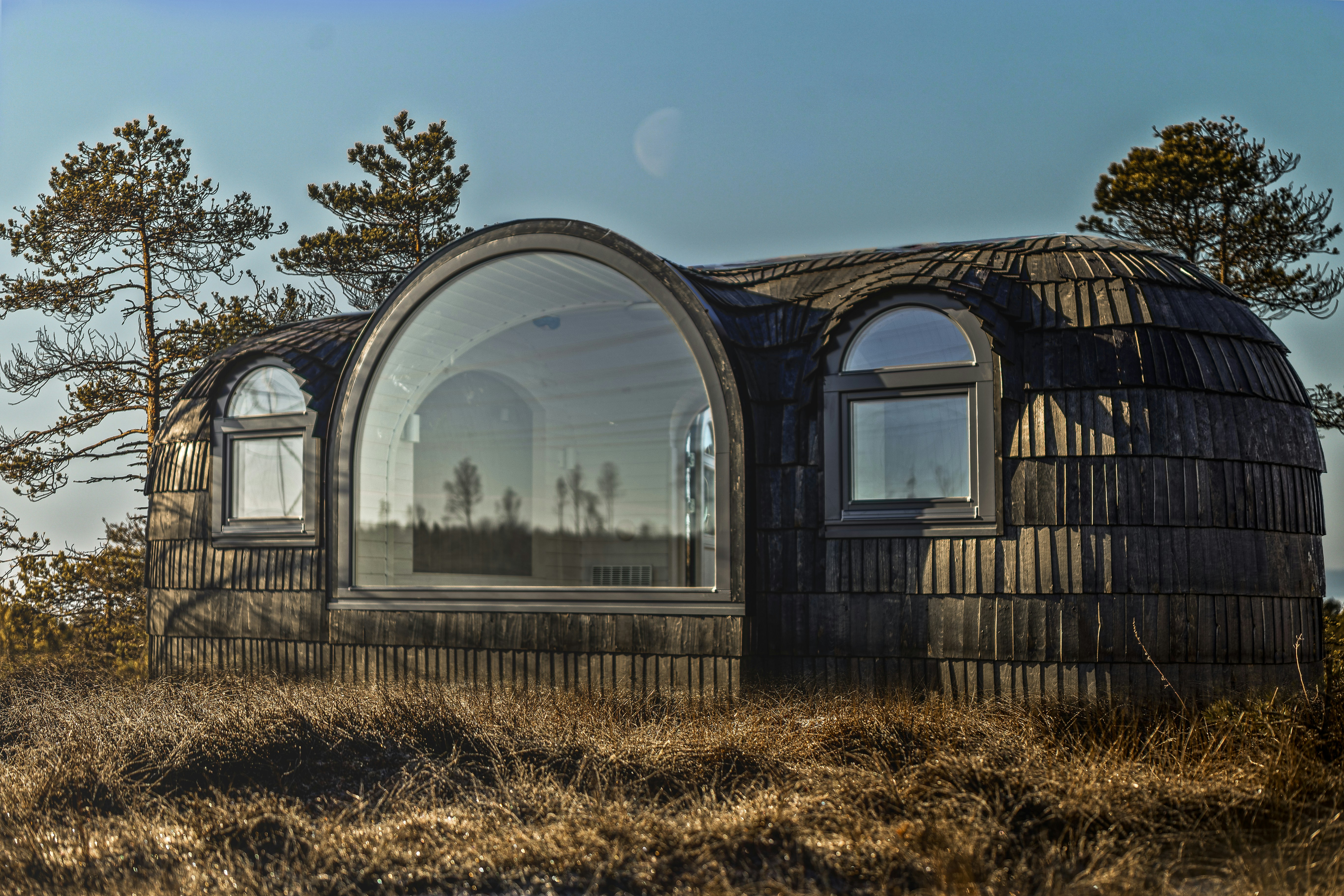 Pequeña estructura de madera sobre campo cubierto de pasto