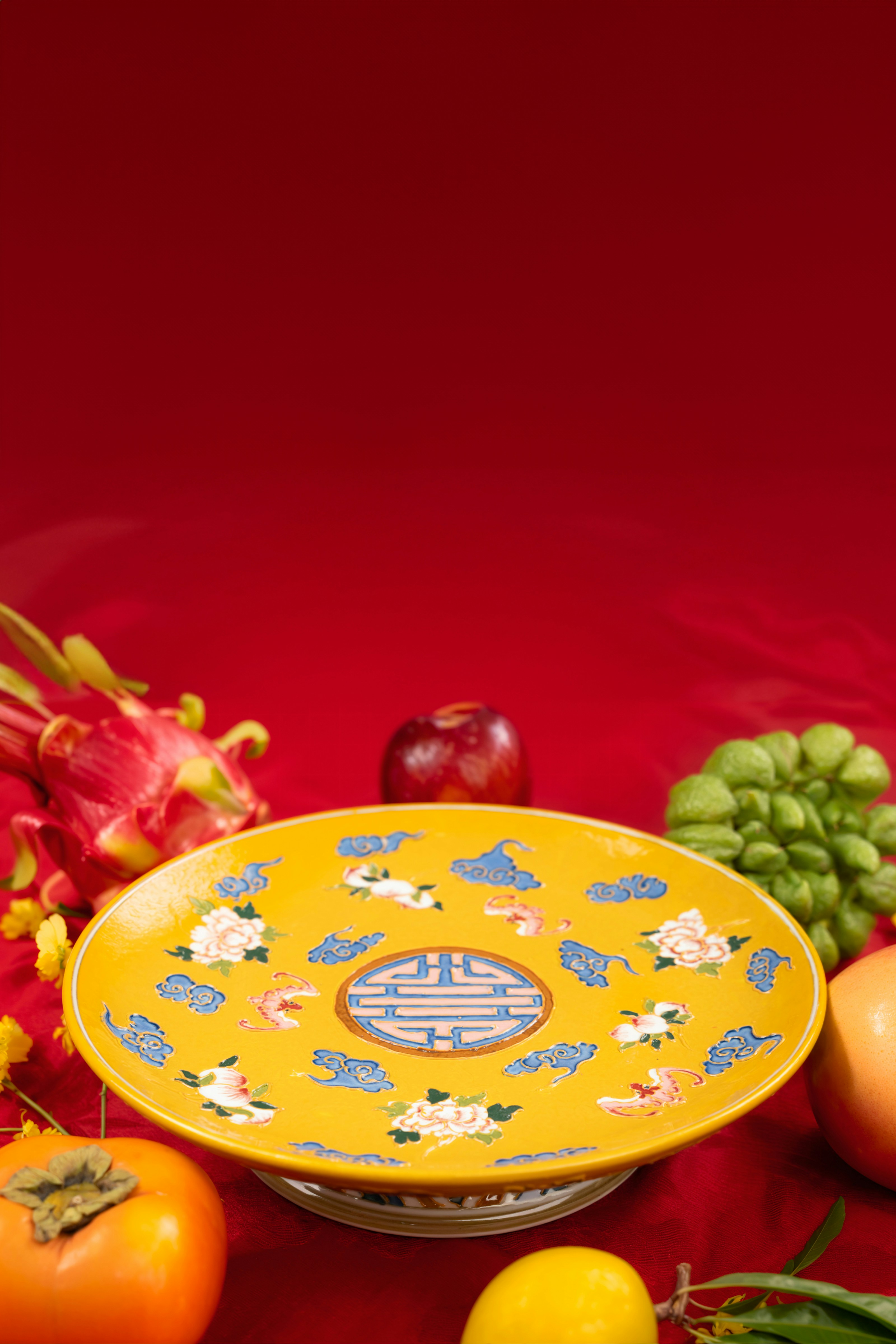 A bowl of fruit and vegetables on a red surface