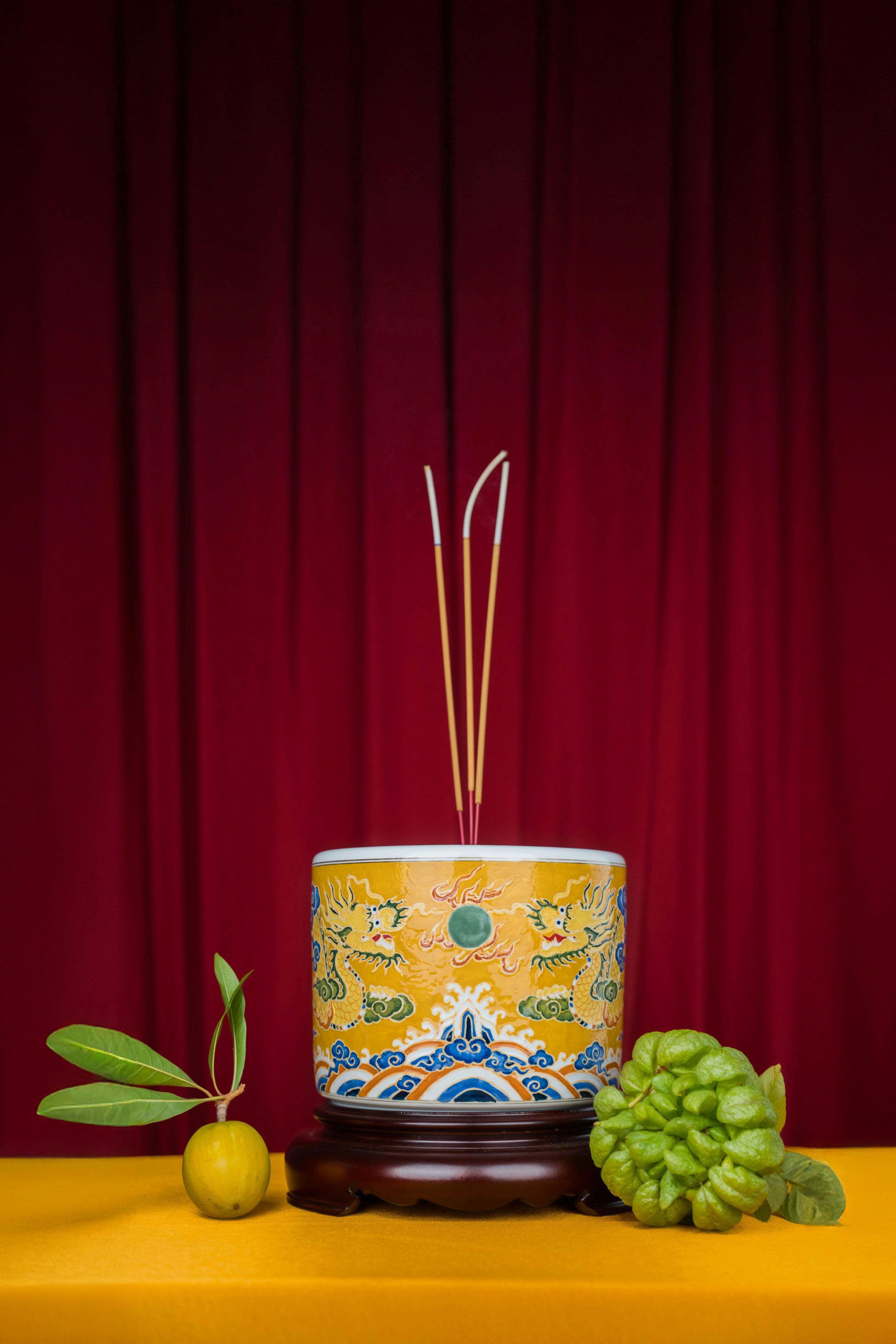 A yellow table topped with a vase filled with fruit