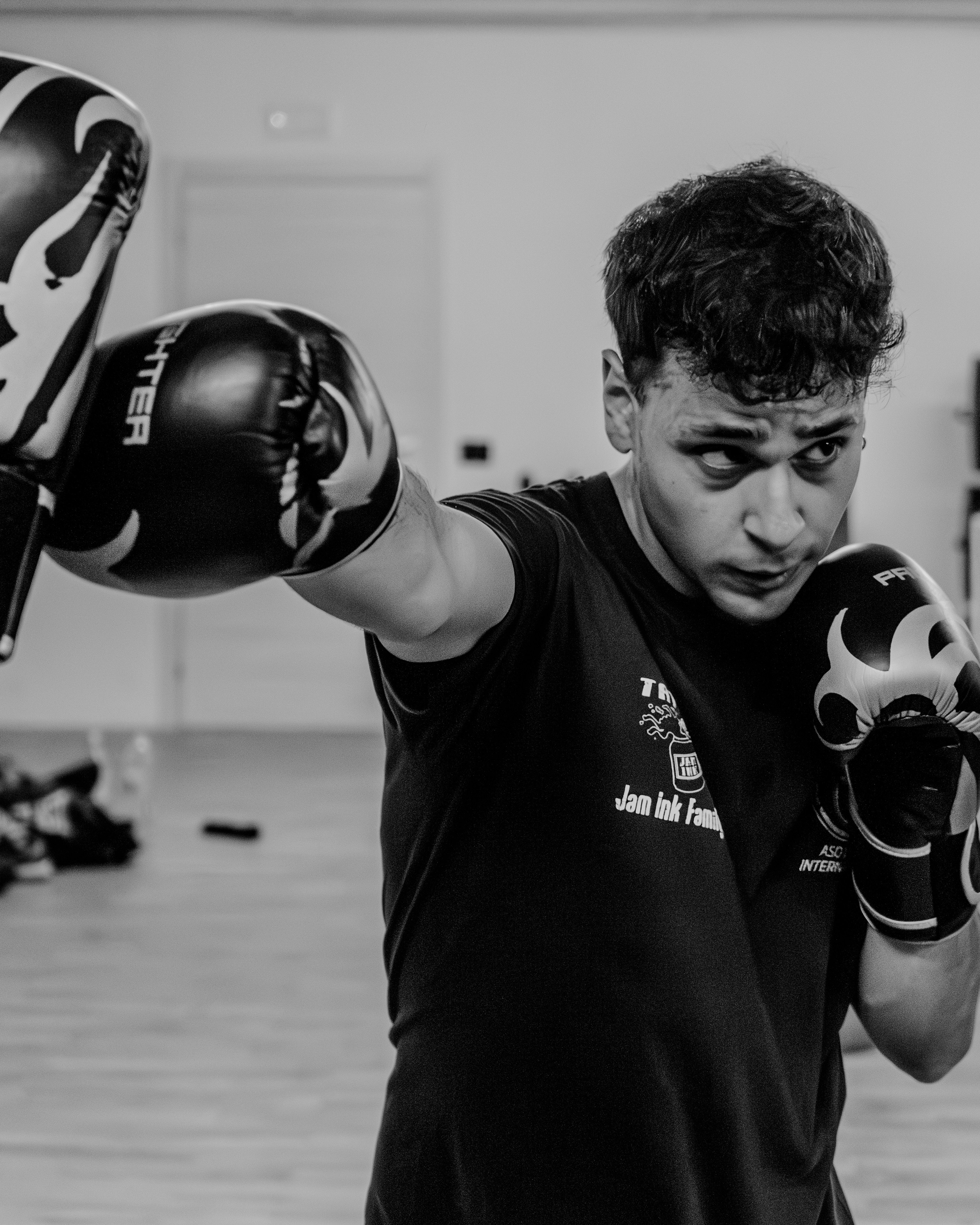 A man wearing boxing gloves in a gym