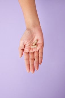 A person holding a pill in their hand