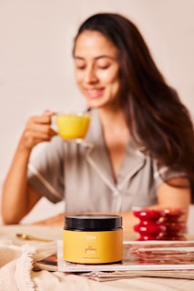 A woman sitting at a table with a cup of coffee