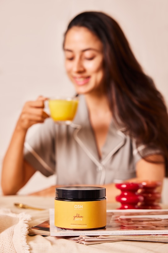 A woman sitting at a table with a cup of coffee