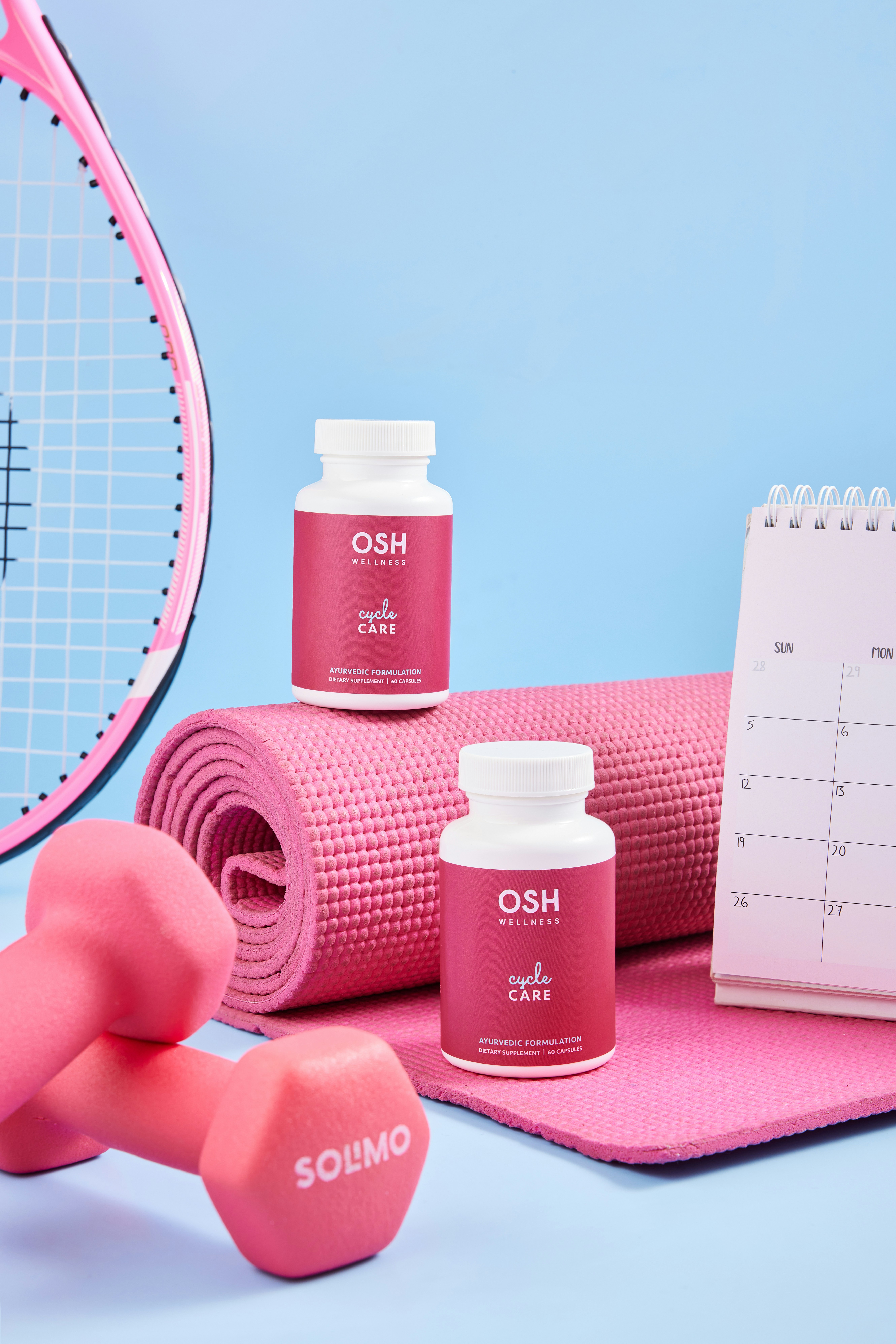 A table topped with pink dumbs next to a tennis racket