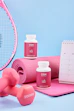 A table topped with pink dumbs next to a tennis racket