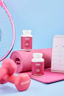 A table topped with pink dumbs next to a tennis racket