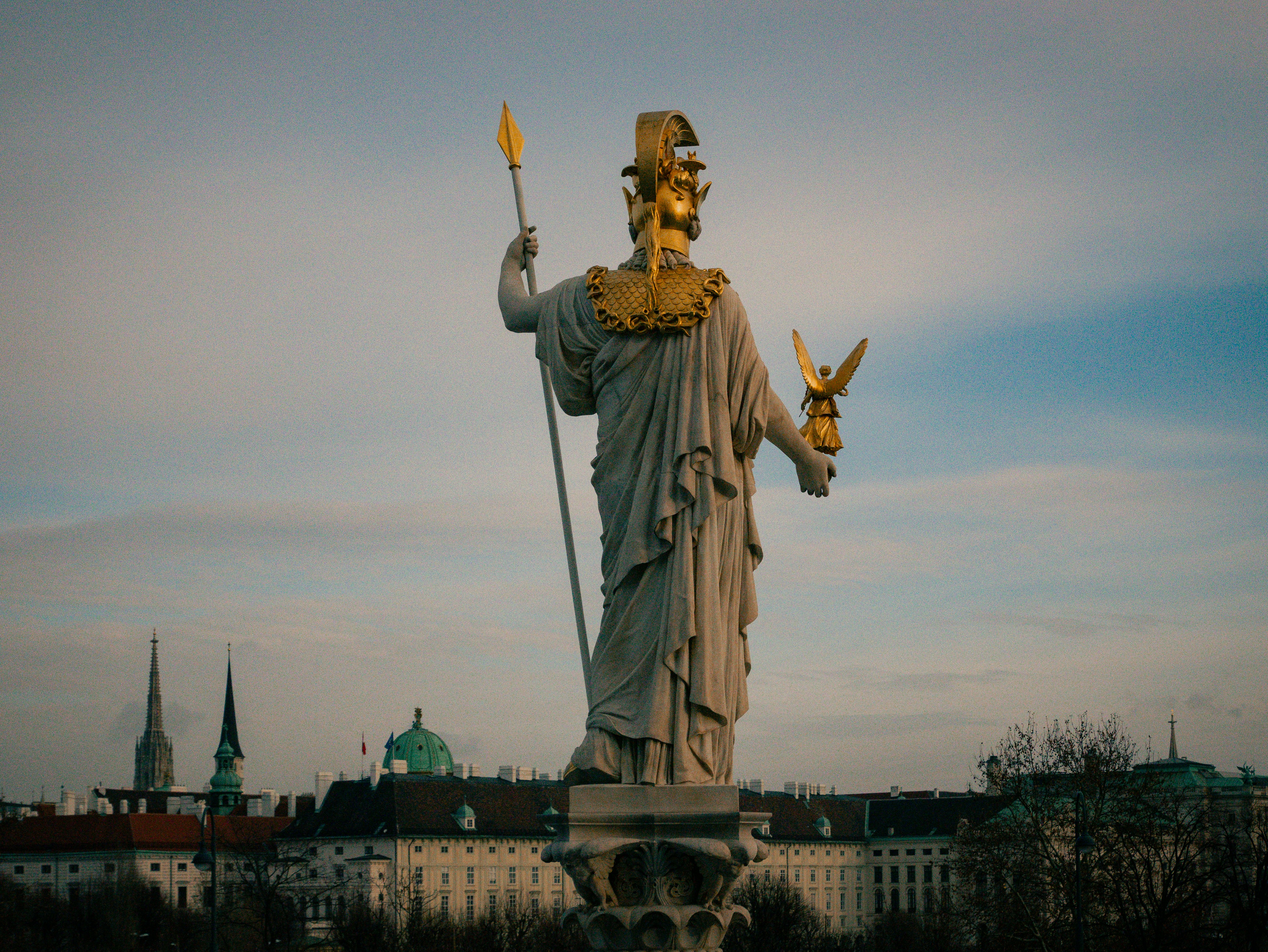The statue of liberty stands in front of a cityscape