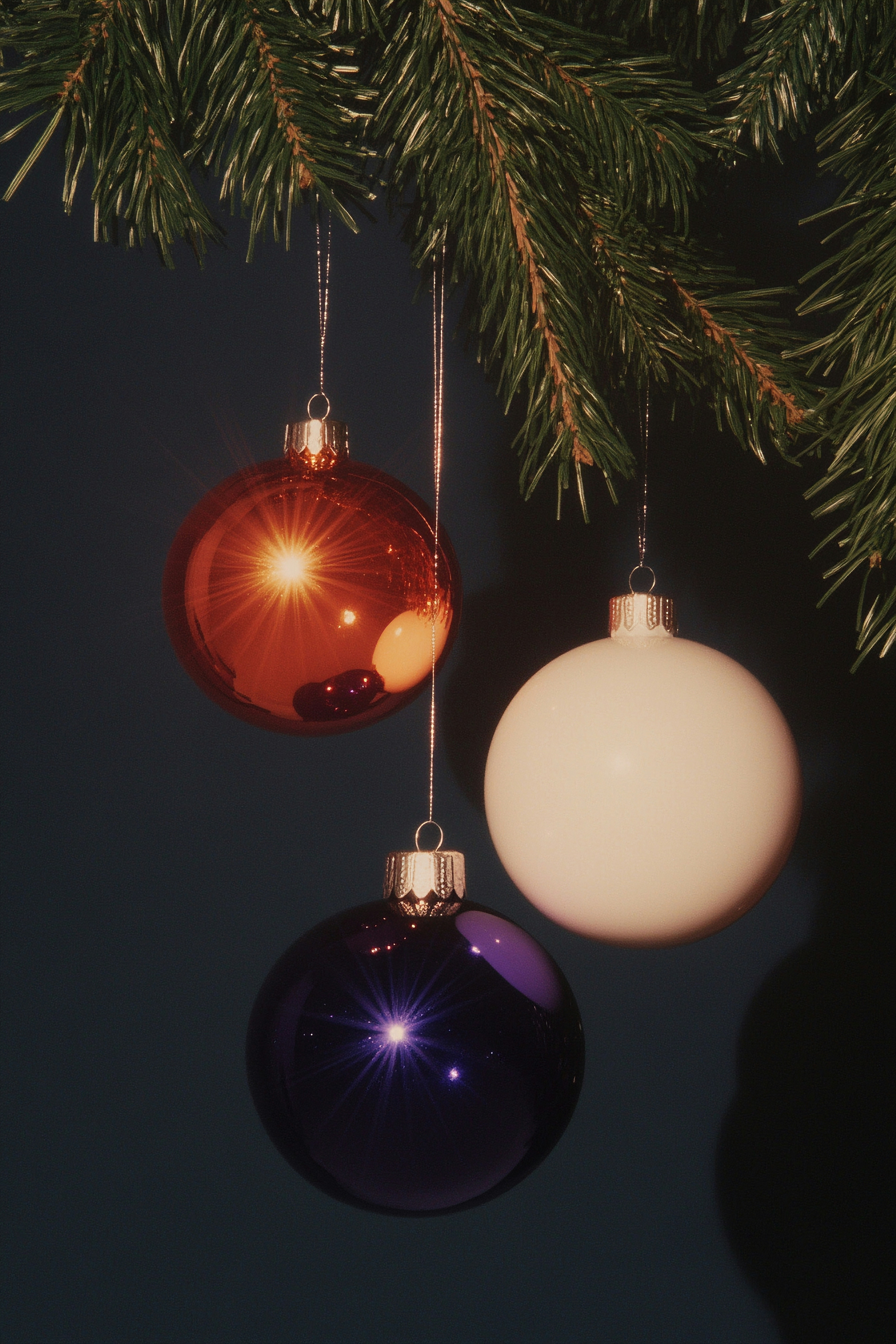 Three ornaments hanging from a christmas tree