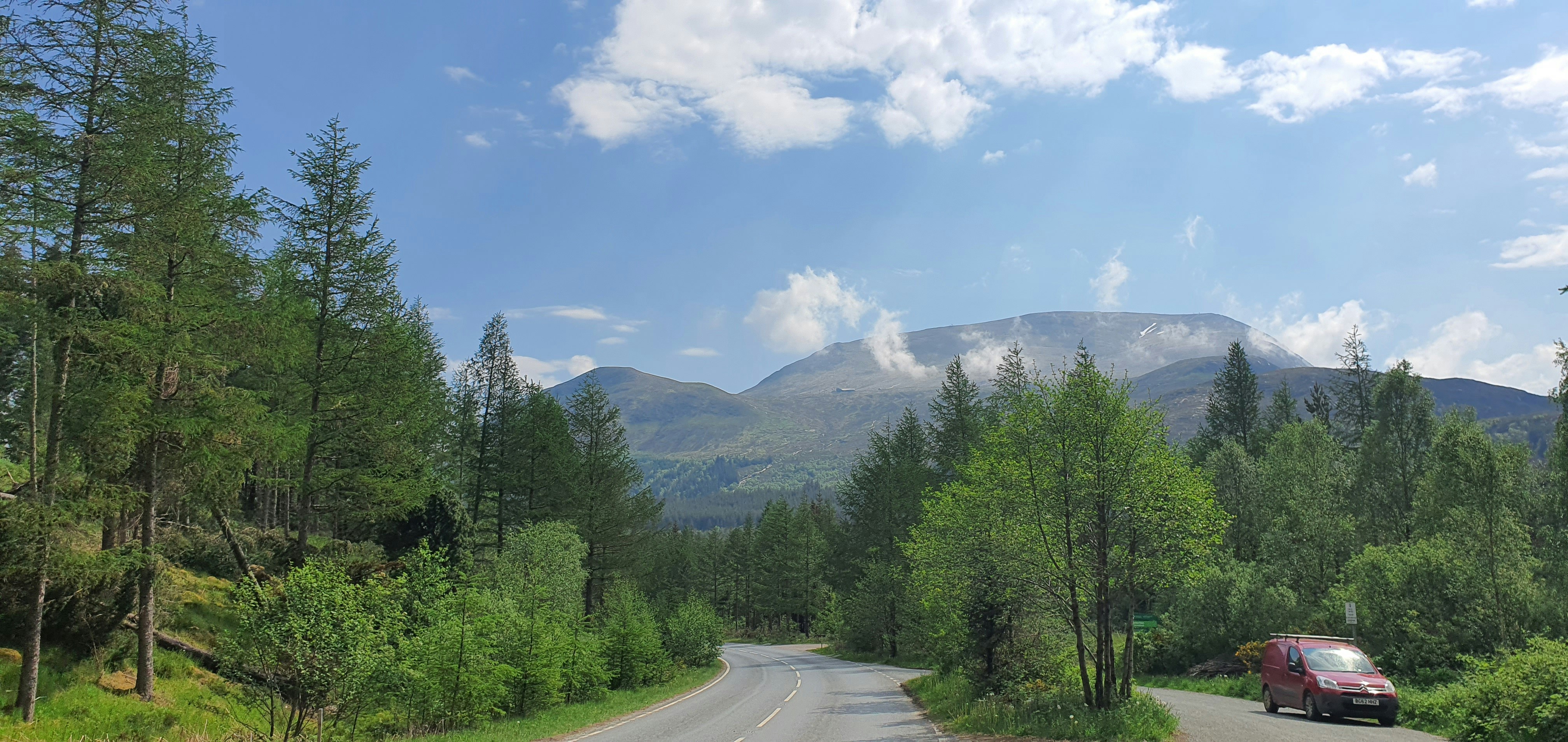 A car driving down a road in the woods