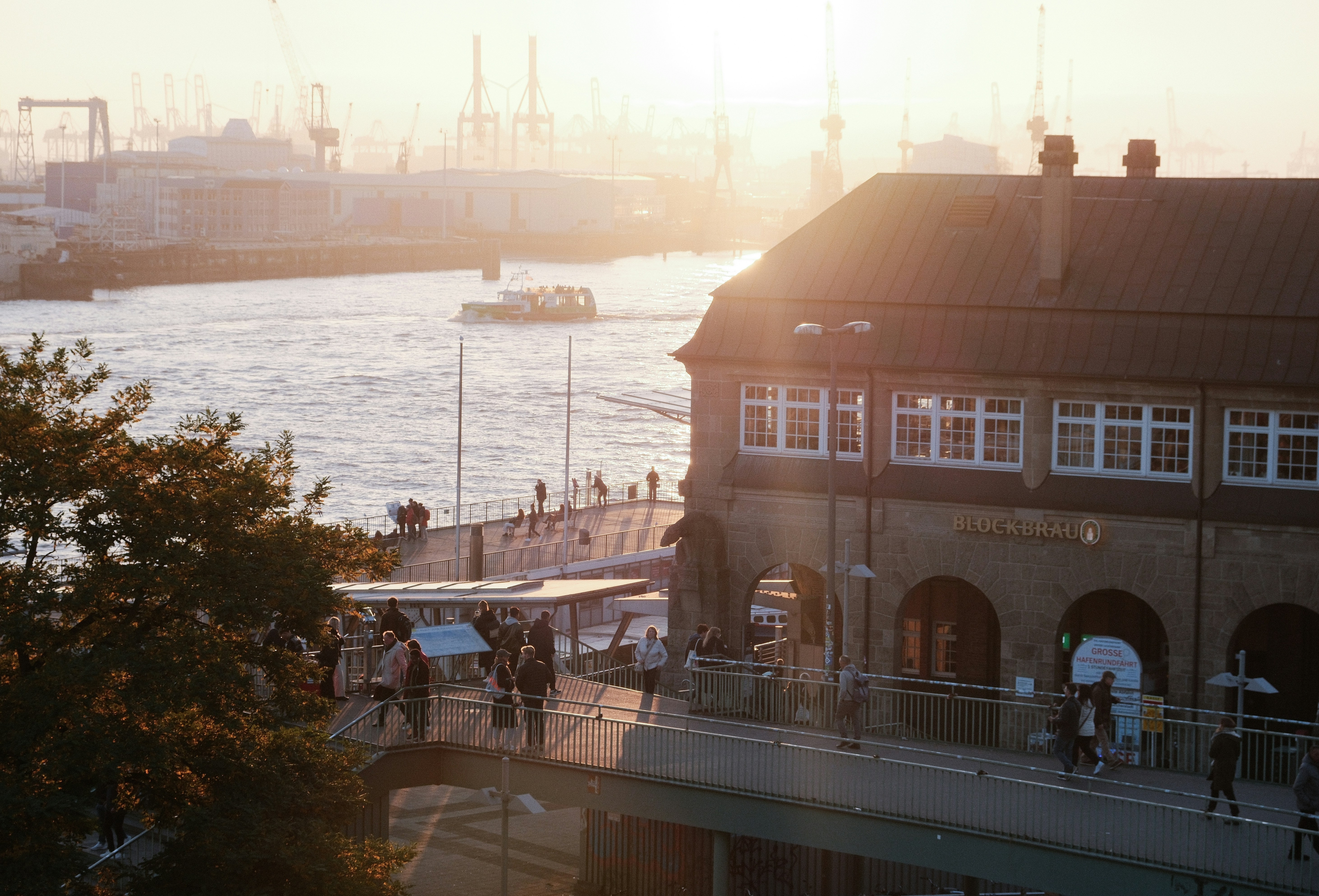 A group of people walking down a street next to a body of water