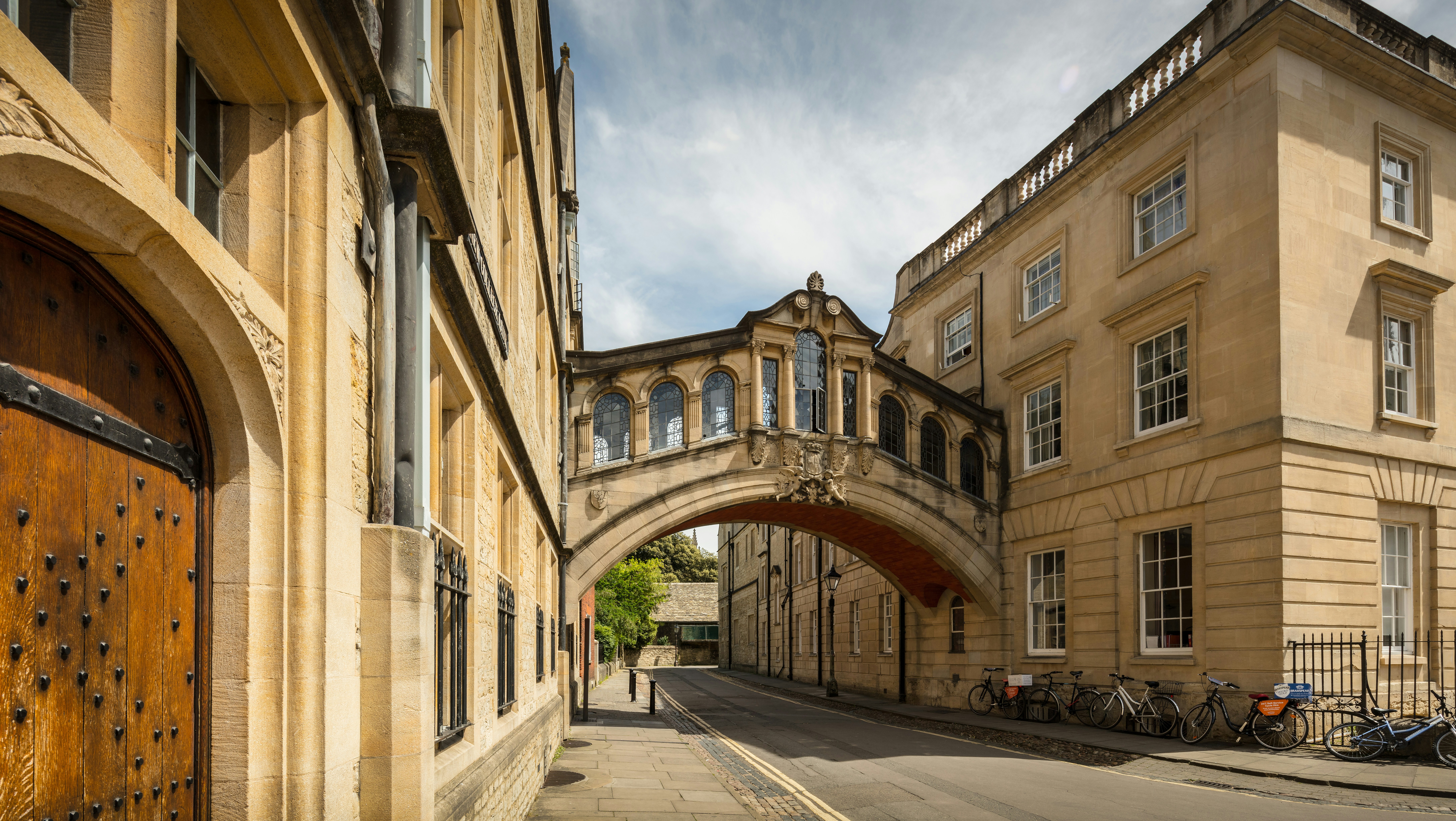 A bridge over a street next to a tall building