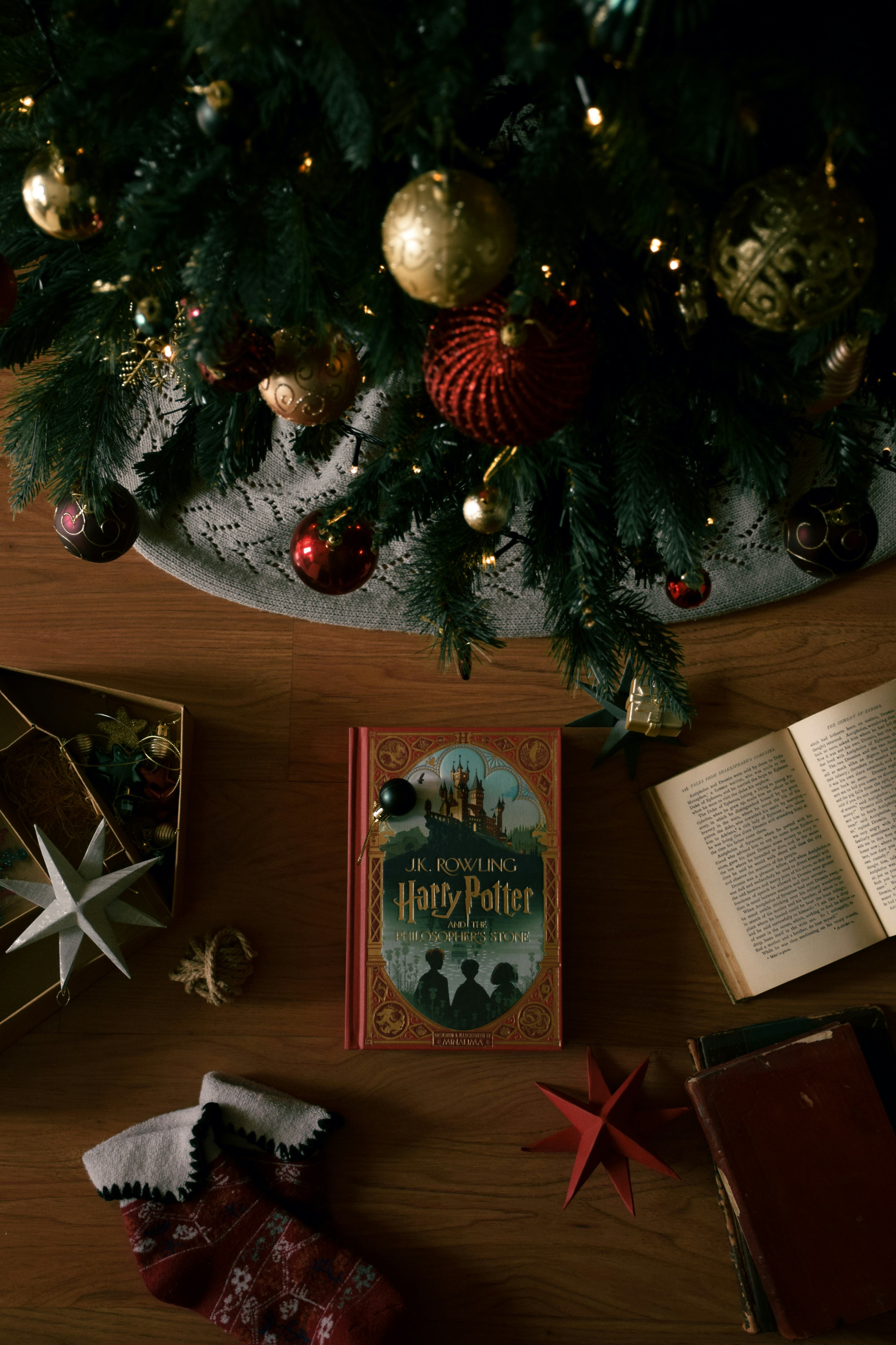 A wooden table topped with books and a christmas tree