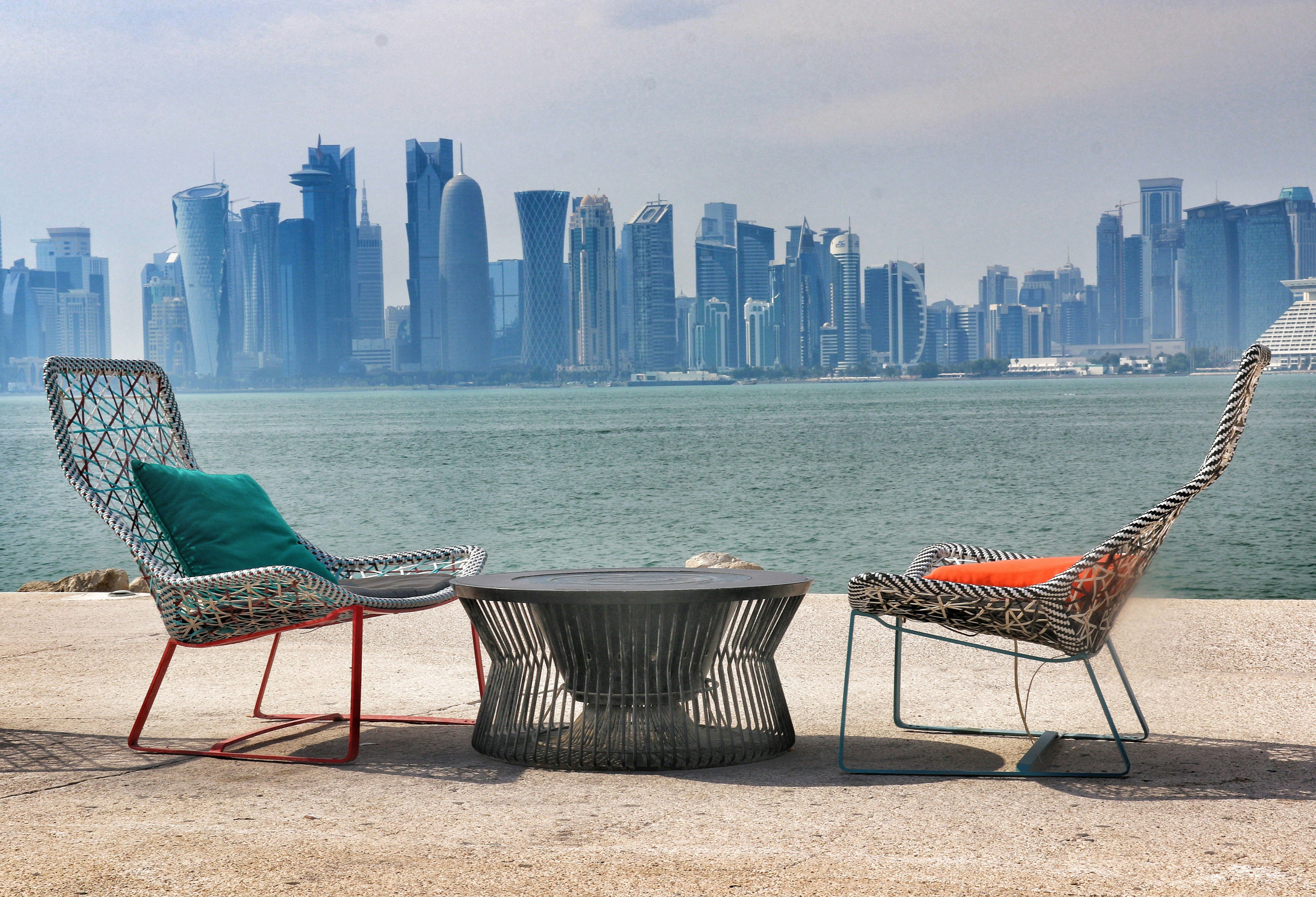 A couple of chairs sitting next to each other near a body of water