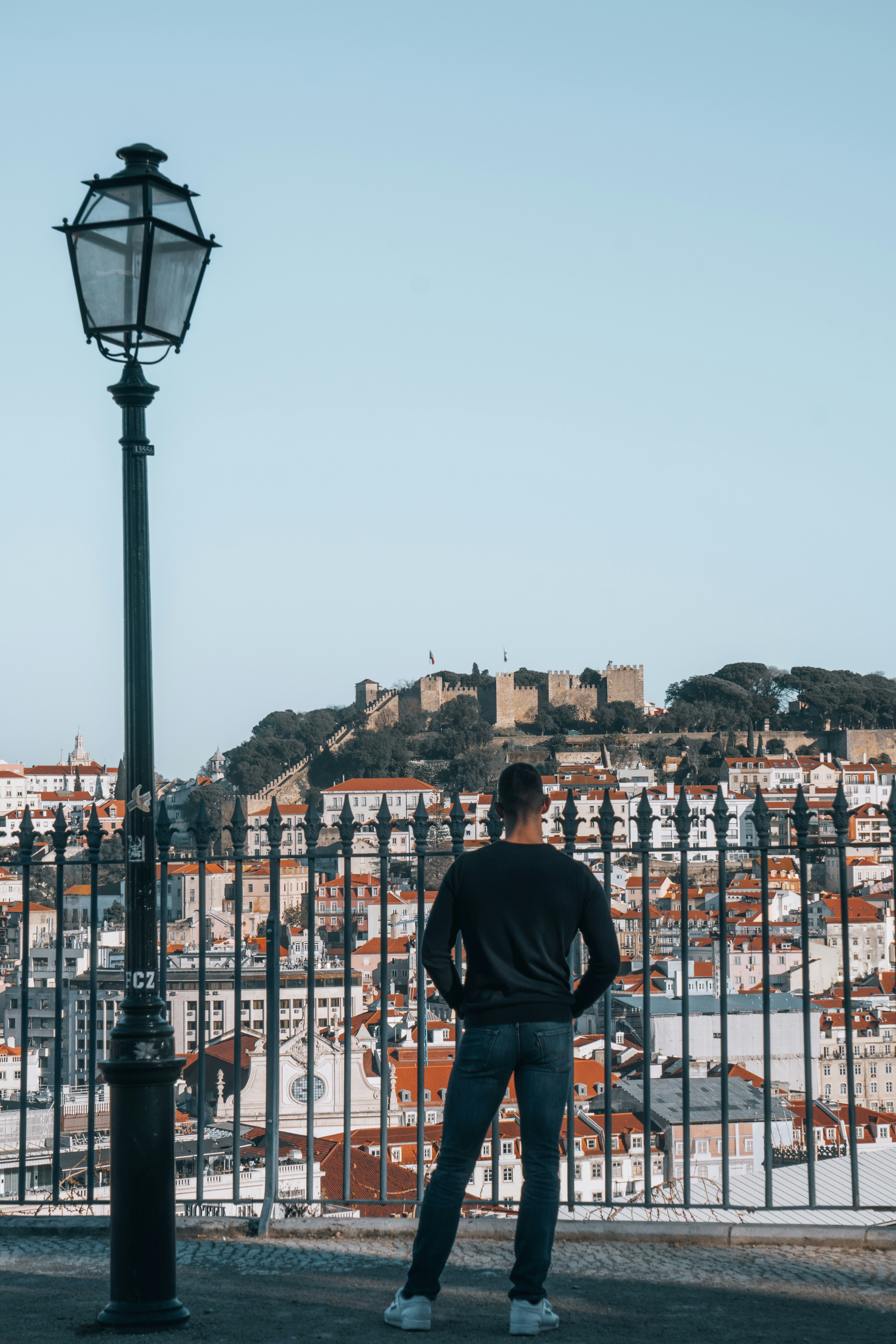 A man standing next to a street light