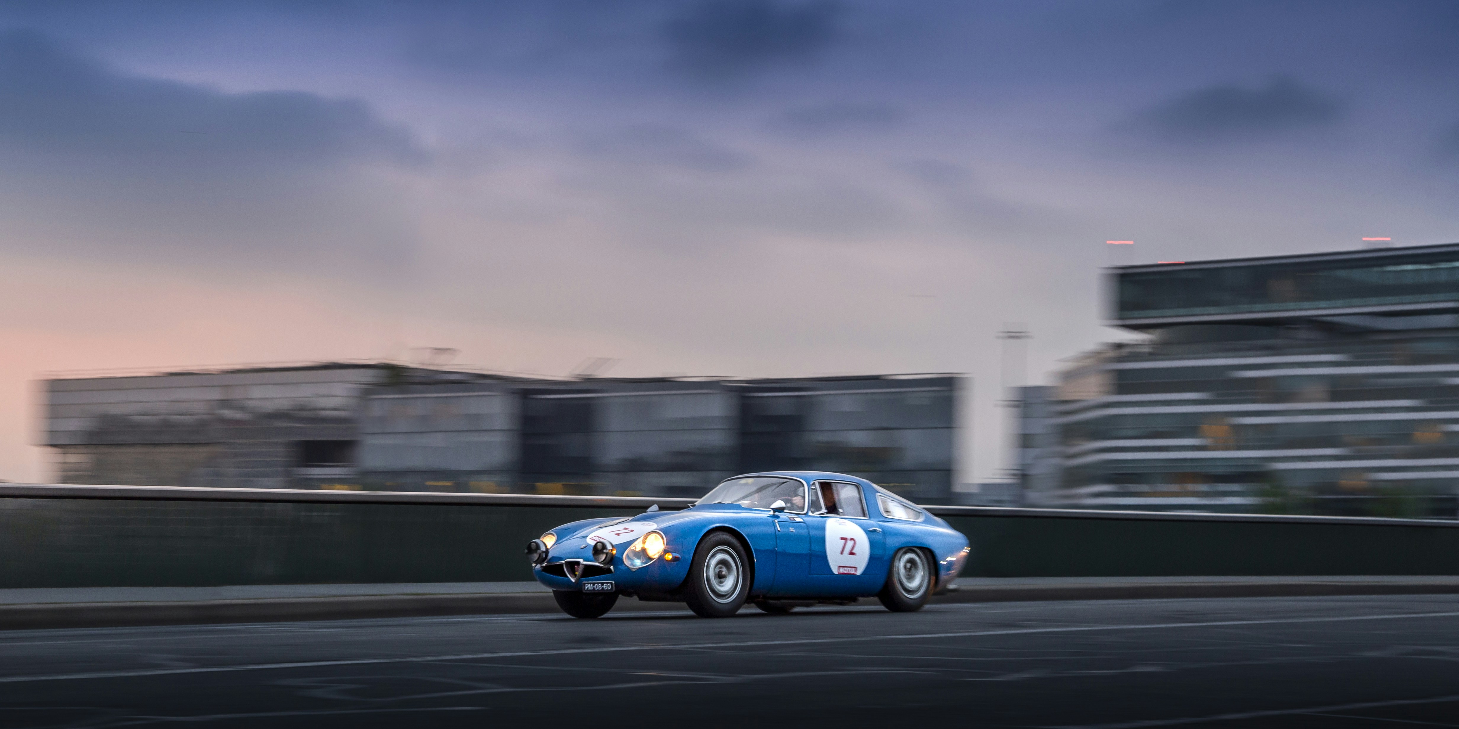 A blue race car driving down a race track photo – Free Car Image on ...