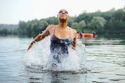 A woman in a swimsuit splashes in the water