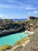 A blue lagoon surrounded by trees on a sunny day
