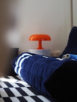 A bed with a blue comforter and a black and white checkered floor