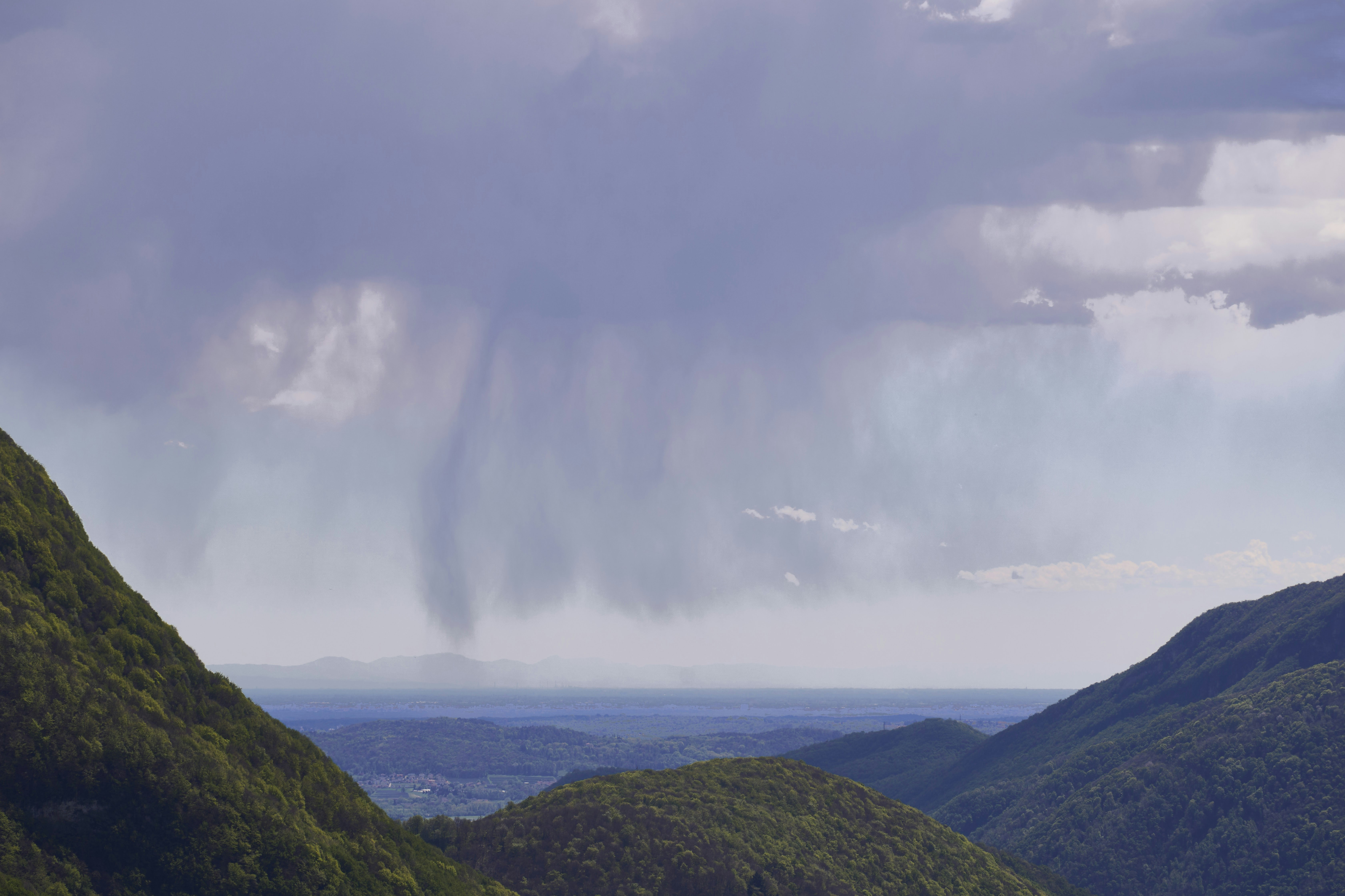 A view of a mountain range with a cloud in the sky