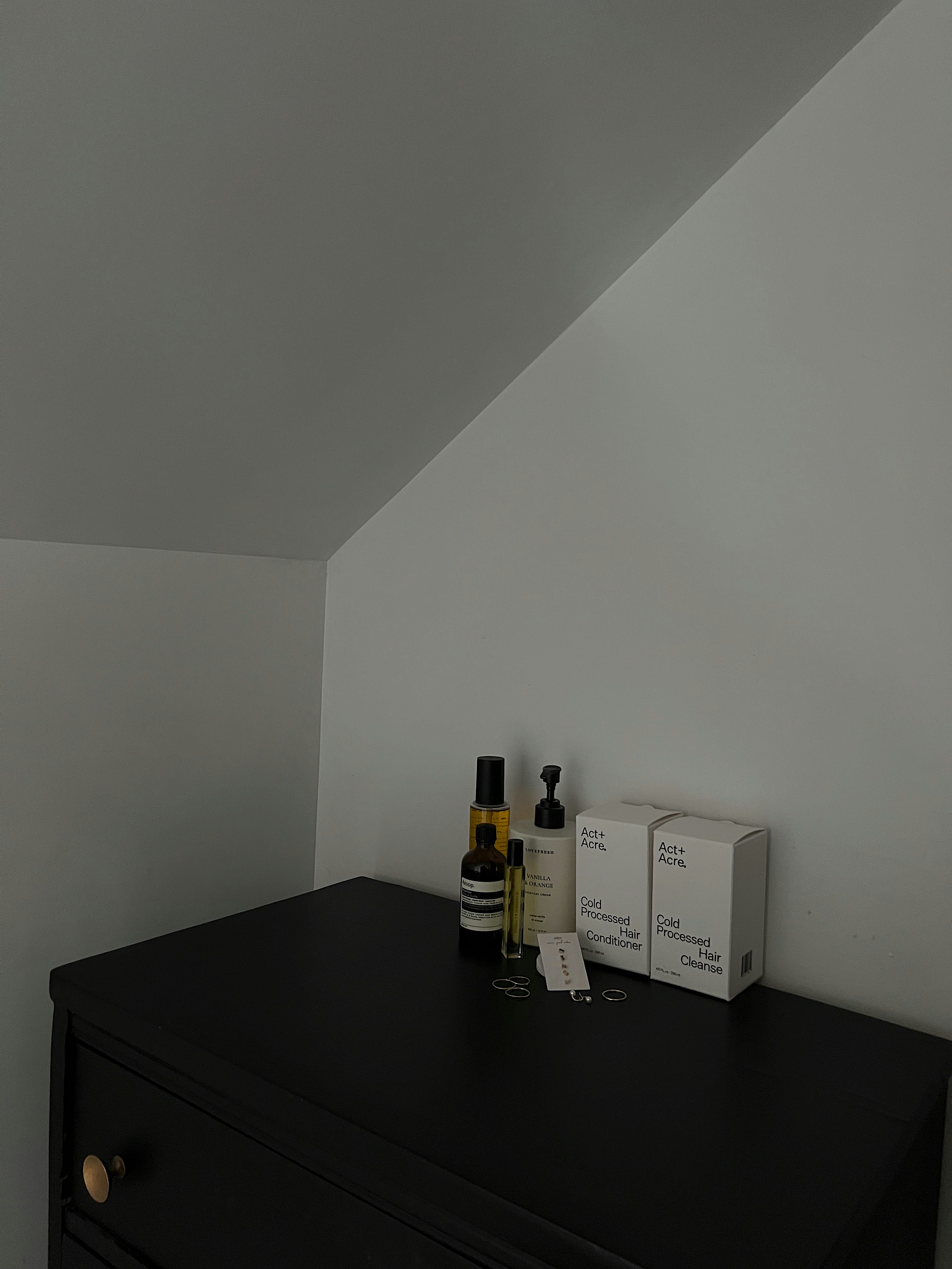 A black dresser sitting in a room next to a white wall