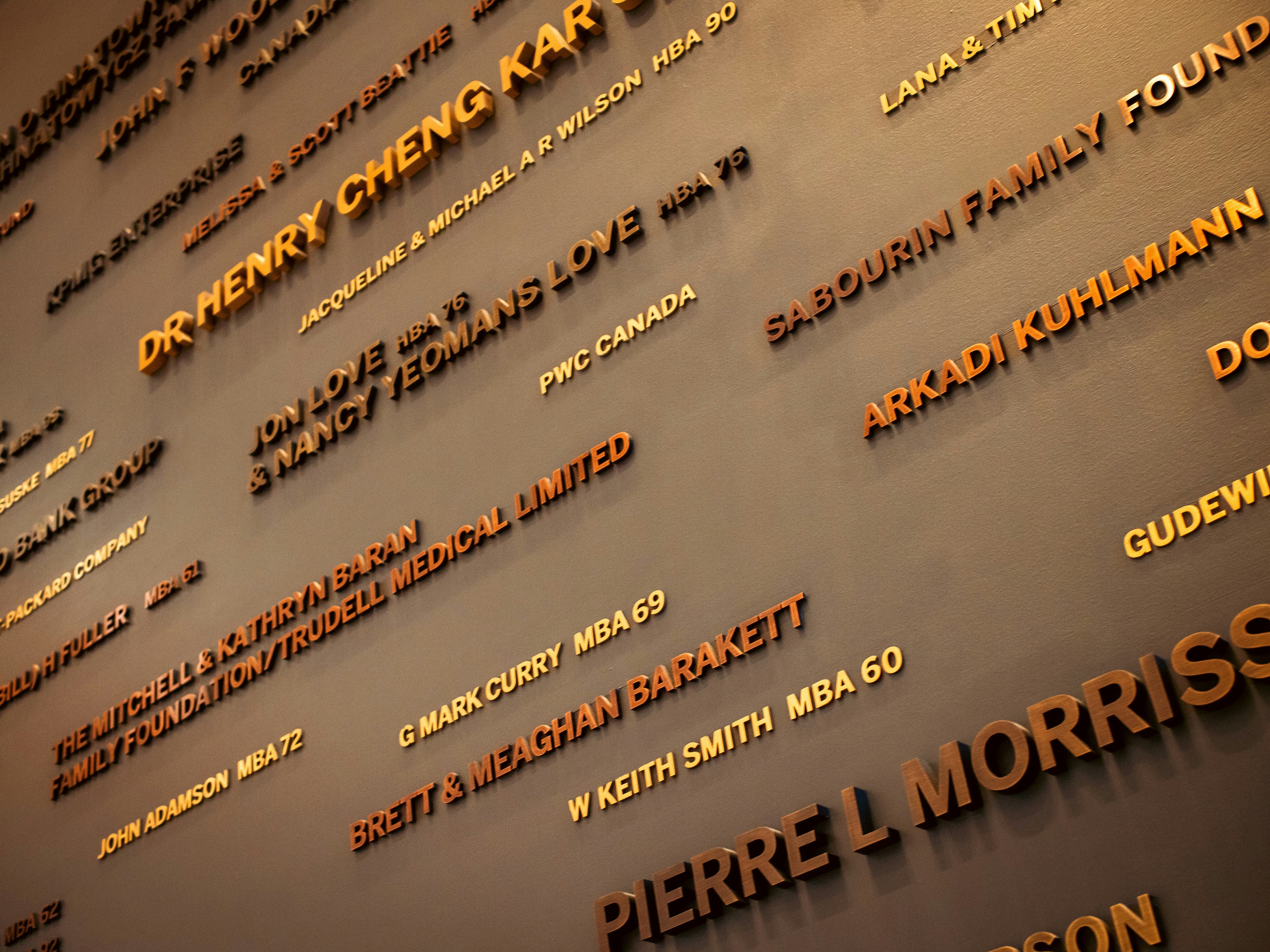 Metallic gold names displayed on a dark grey recognition wall.