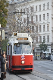 A red and white trolley on a city street