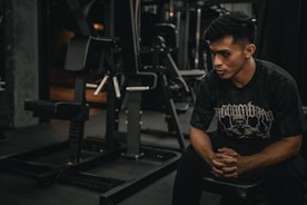 A man sitting on a bench in a gym