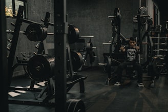 A man sitting in a gym with a barbell
